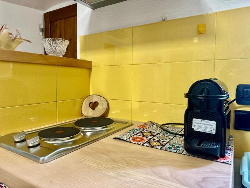 a kitchen with a stove and a yellow wall at La Casa di Ayda in Riccò del Golfo di Spezia