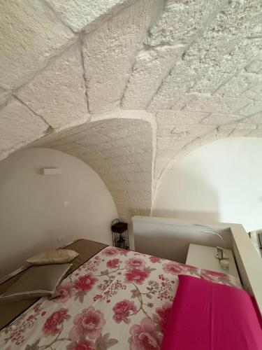a bedroom with a bed with a pink blanket at Al Vico in Carpignano Salentino