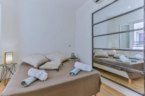 Cette chambre comprend deux lits et un grand miroir. dans l'établissement Massena Cours - Terrasse - Zone piétonne, à Nice