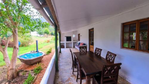a dining room with a table and a bath tub at Berge toe - Spanspek se plek Farmstay in Bonnievale
