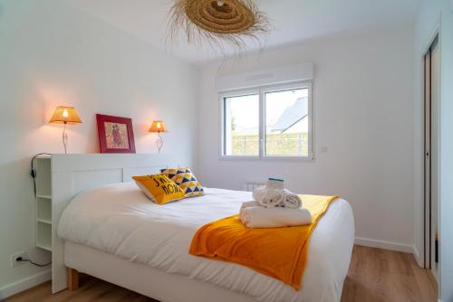 a bedroom with a bed with two towels on it at Le Bas du Nelud - Appt dans maison avec jacuzzi in Locmariaquer