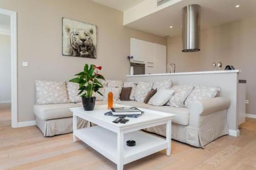 un salon avec un canapé blanc et une table dans l'établissement JEAN JAURES - 90m2 wAC 2min to Beach, à Nice