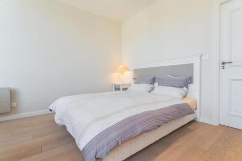 - une chambre blanche avec un grand lit blanc et des oreillers bleus dans l'établissement JEAN JAURES - 90m2 wAC 2min to Beach, à Nice