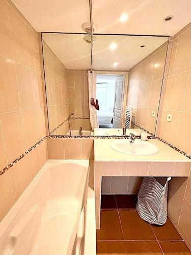 une salle de bain avec une baignoire, un lavabo et un miroir dans l'établissement Charmant 2 pièces avec terrasse proche plage, à Antibes