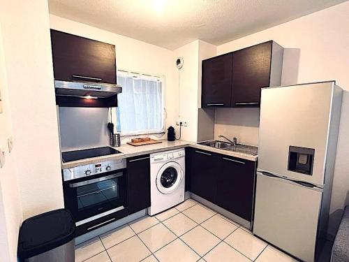 Il comprend une cuisine équipée d'un réfrigérateur et d'un lave-linge/sèche-linge. dans l'établissement Charmant 2 pièces avec terrasse proche plage, à Antibes