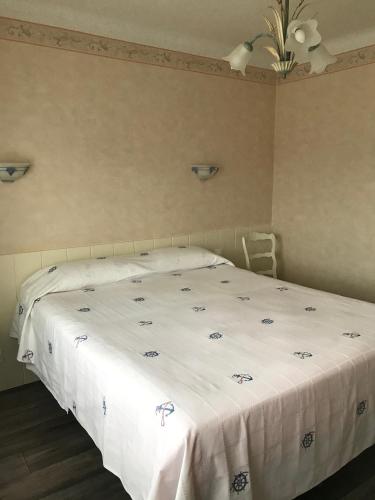 - une chambre avec un lit et une couverture blanche dans l'établissement Le Bretagne, à Assérac