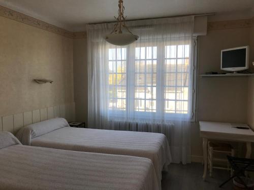 une chambre avec deux lits et une fenêtre dans l'établissement Le Bretagne, à Assérac