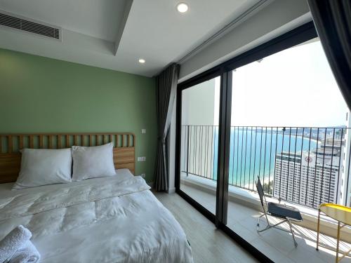 a bedroom with a bed and a large window at Gold Coast Apartment Seaview in Nha Trang