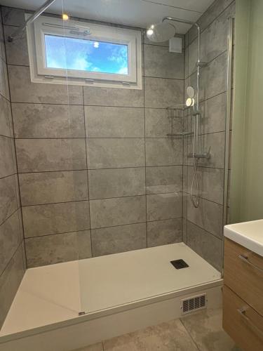 La salle de bains est pourvue d'une douche, d'une baignoire et d'une fenêtre. dans l'établissement Grand appartement - Le Brindeau - 3 ch, au Havre