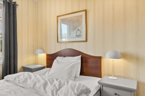 a bedroom with a bed and two night stands with lamps at Halden Grand hotell in Halden