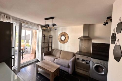 un salon avec un canapé et une table dans l'établissement Charming apartment with superb terrace - Vallauris, à Vallauris