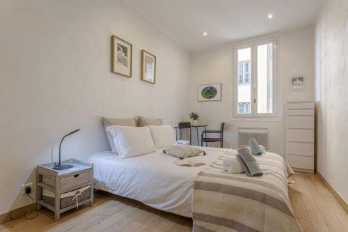 une chambre blanche avec un grand lit et un bureau dans l'établissement GAMBETTA - Charming 2 bedroom - Near Promenade, à Nice