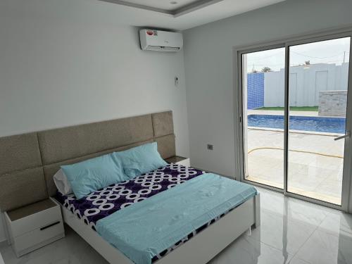a bedroom with a bed and a sliding glass door at Dar khadouja in Taguermess