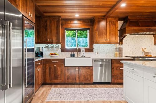 a kitchen with wooden cabinets and a stainless steel refrigerator at Tropical Riverhouse Retreat in Anderson