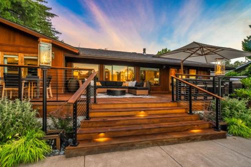 a home with a wooden staircase with an umbrella at Tropical Riverhouse Retreat in Anderson