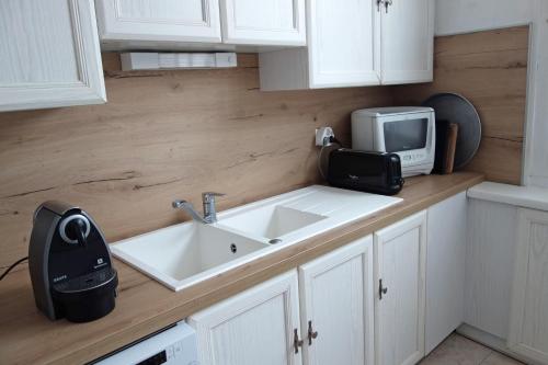 a kitchen with a sink and a microwave at Le Balcon sur Grignan in Grignan