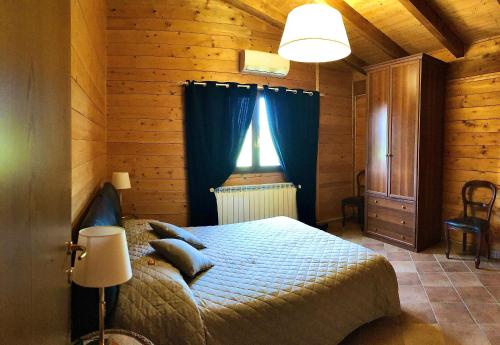 a bedroom with a bed and a window with blue curtains at Agriturismo BioCore - Collepietro - Mosciano S Angelo in Collepietra