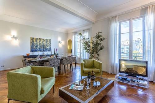 un salon avec un canapé, une télévision et une table dans l'établissement VICTOR HUGO - Beautiful Apartment - View over Garden, à Nice