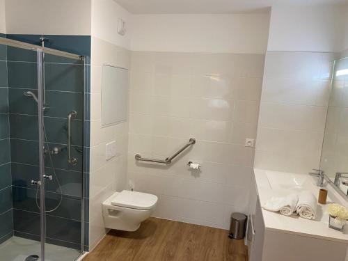 une salle de bain avec toilettes et douche en verre dans l'établissement La Résidence Cholet, à Cholet