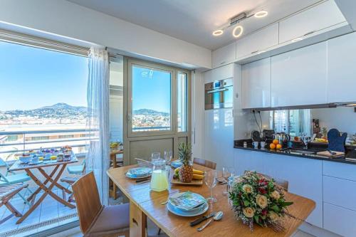 une cuisine et une salle à manger avec une table et un balcon dans l'établissement PALAIS MED - Palais Méditerranéen - Panoramic view, à Nice