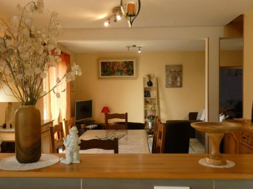 un salon avec un vase de fleurs sur une table dans l'établissement Gîte Le Coup dAir en Périgord Noir, à Tursac