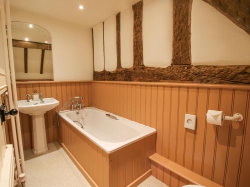 une salle de bain avec une baignoire et un lavabo dans l'établissement Courtyard Cottage, à Great Bolas