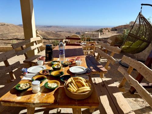a picnic table with food on it with a view at Dar Fatma Toujane in Tūjān