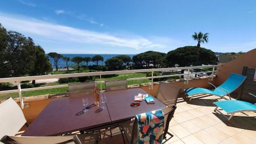 une table et des chaises sur un balcon avec vue sur l'océan dans l'établissement Les Rivages - 6-8p - Front de mer, piscine, aux Issambres