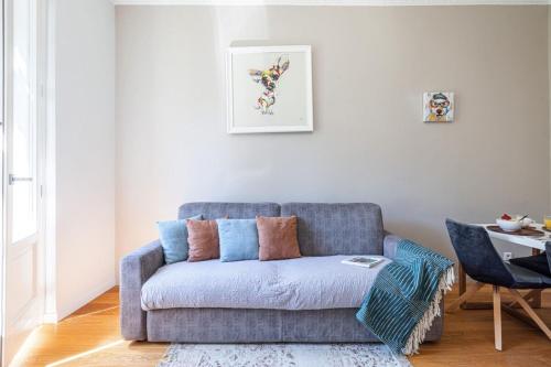 un salon avec un canapé bleu et une table dans l'établissement JOFFRE 49-D - Charming 2 bedroom - Carré d'Or, à Nice