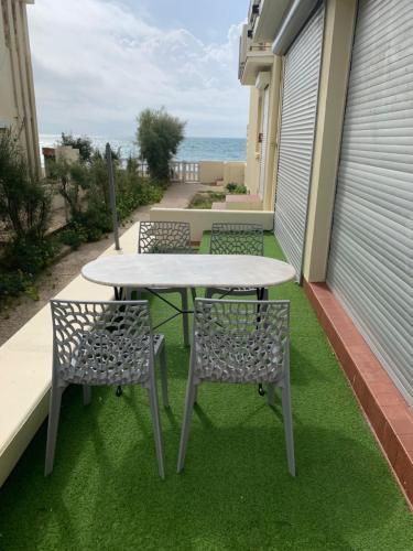 d'une table et de deux chaises sur un balcon donnant sur l'océan. dans l'établissement Appartement Palavas-les-Flots, Front de mer, à Palavas-les-Flots