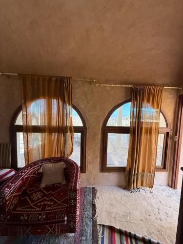 a room with two windows and a bed and a couch at Dar Fatma Toujane in Tūjān