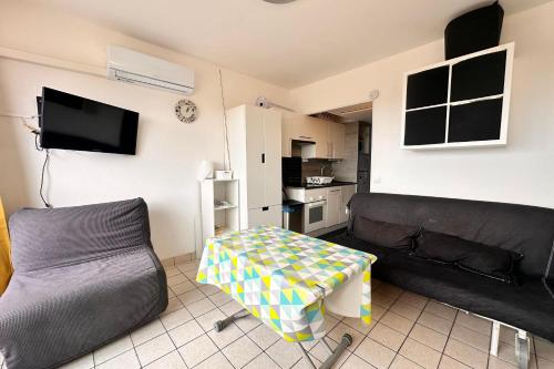 un salon avec un canapé et une table dans l'établissement Les Coquillages - Résidence avec piscine, au Grau-du-Roi