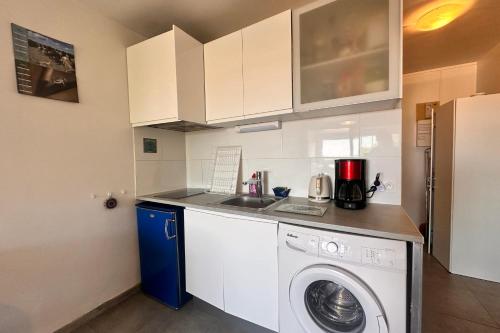 une cuisine avec une machine à laver et un évier dans l'établissement Studio Les Floralies, au Grau-du-Roi
