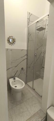 a bathroom with a toilet and a glass shower at Little Button House Marina in Cagliari