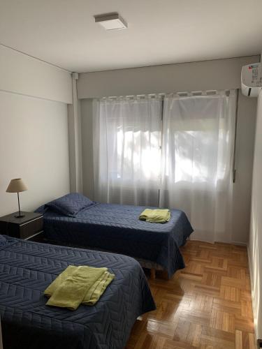 a bedroom with two beds and a window at Microcentro Mendoza in Mendoza