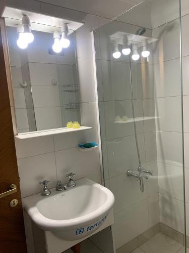 a bathroom with a sink and a shower with a mirror at Microcentro Mendoza in Mendoza