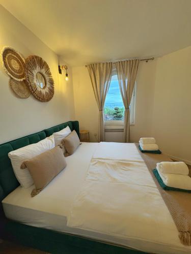 a large white bed in a room with a window at Villa Nada in Lovran