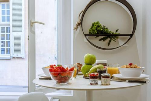 - une table avec un bol de fruits et un miroir dans l'établissement BUNICO 1 - Old Town Renovated Studio, à Nice