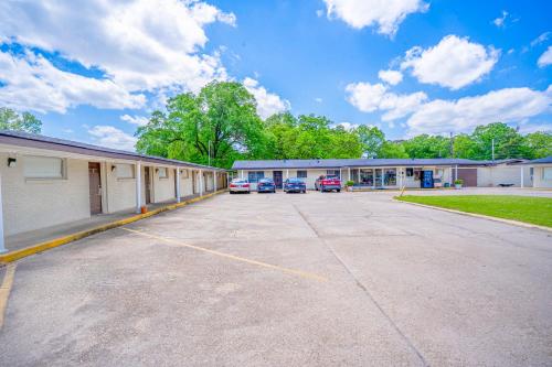 a building with cars parked in a parking lot at Cypress Inn Motel By OYO West Monroe I-20 in Monroe