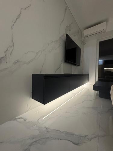 a living room with a television on a white wall at Royal Apartments in Skopje