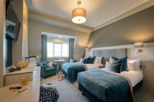 a hotel room with two beds and a chair at Gleneagle Killarney in Killarney