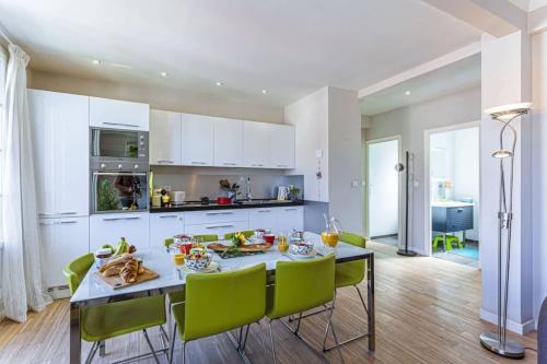 une cuisine avec une table à manger et des chaises vertes dans l'établissement BERLIOZ 1 - City Center 2 rooms - Last Floor, à Nice