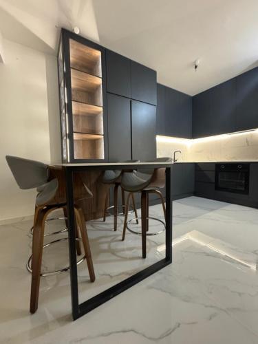a kitchen with a black table and chairs at Royal Apartments in Skopje