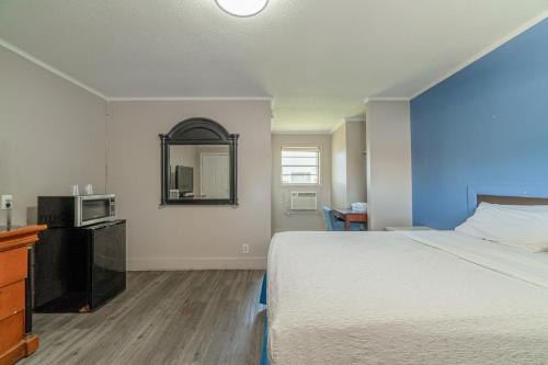 a hotel room with a bed and a mirror at Cypress Inn Motel By OYO West Monroe I-20 in Monroe