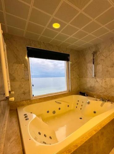 a large bath tub in a bathroom with a window at Beyaz Ev Otel Restaurant in Eskiömerler