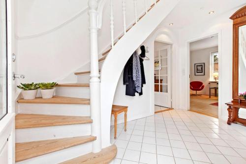 a staircase in a home with white walls and wooden floors at Entire multi-room apartment in patrician villa in Slagelse