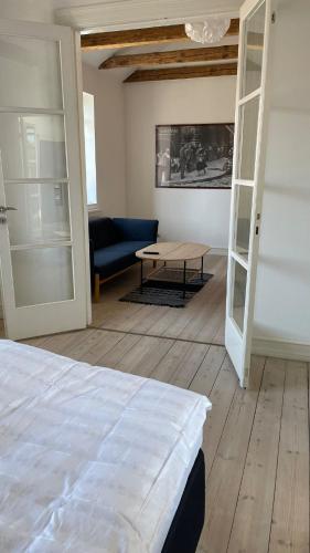 a room with a bed and a couch and a table at Entire multi-room apartment in patrician villa in Slagelse