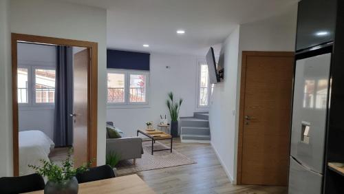 a living room with a bed and a room with a door at Apartamentos Porta do Vez Centro Histórico Moderno in Arcos de Valdevez