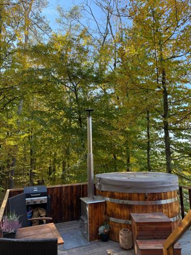 a wooden deck with a hot tub and a grill at KarpatyGlamp in Rudimov