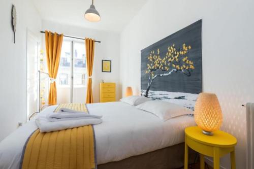 - une chambre avec un lit blanc et un tabouret jaune dans l'établissement GIOFFREDO 14 - Spacious apartment with balcony, à Nice